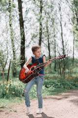 little girl playing guitar standing on the path in the city Park