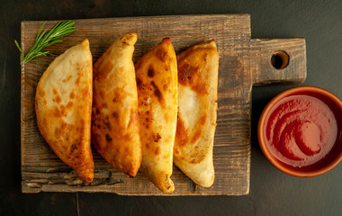 Latin American fried empanadas with tomato sauce.  Top view