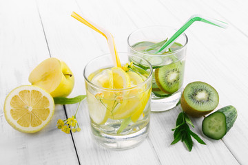 Set of diet drinks, mineral water in a glass, fresh green kiwi, mint and cucumber, lemon and yellow apple. Detoxification and cleansing of body.