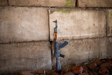 a Kalashnikov rifle on the brick background of the war