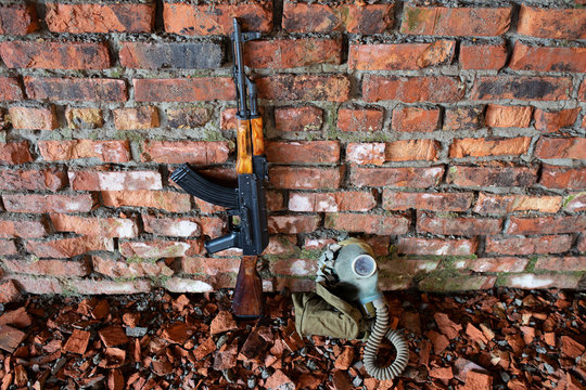 a Kalashnikov rifle on the brick background of the war