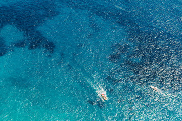 Yacht at the sea in Italy. Aerial view of luxury floating boat on transparent turquoise water at sunny day. Summer seascape from air. Top view from drone. Seascape with motorboat in bay.