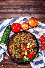 Groats with lentils and vegetables on wooden table