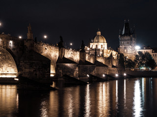 Fototapeta na wymiar Illuminated Charles Bridge reflected in Vltava River by night. Prague, Czech Republic