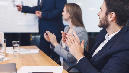 Business colleagues applauding to reporter at seminar
