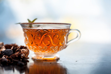 Tamarind or imli or amli in a clay bowl along with its roasted seeds and extract tea in a...
