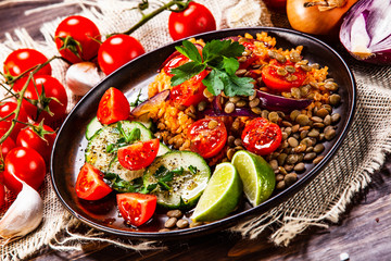 Groats with lentils and vegetables on wooden table