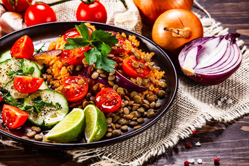 Groats with lentils and vegetables on wooden table