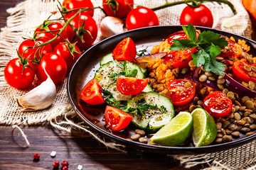 Groats with lentils and vegetables on wooden table