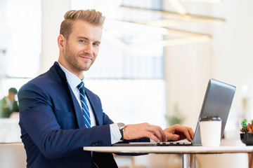 smart caucasian businessman in suit working with laptop and smartphone communication with happiness and focus successsful business ideas concept