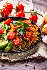 Groats with lentils and vegetables on wooden table