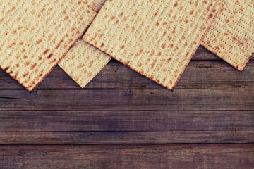 Four pieces of matzah or matza on a vintage wood background with copy space or text space.