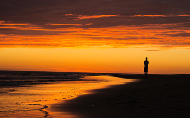 Fototapeta premium silhouette of man on the beach at sunset