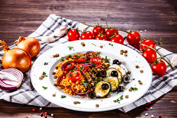 Groats with lentils and vegetables on wooden table