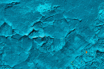 Imperfect concrete surface. Cracked blue paint close-up. Damage texture in macro. Grungy plaster. Old stucco textured background. Rough faded uneven obsolete wall. Peeling of old paint. Flaking of dye