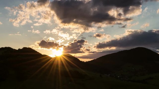 Magic sunrise with sun and clouds over mountains Time lapse