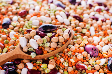 collection set of beans, legumes, peas, lentils on wooden spoons on legumes background