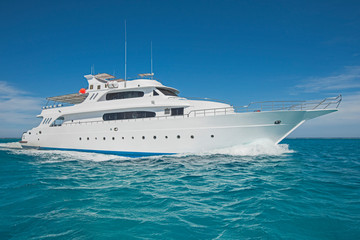 Fototapeta na wymiar Luxury motor yacht sailing out on tropcial sea