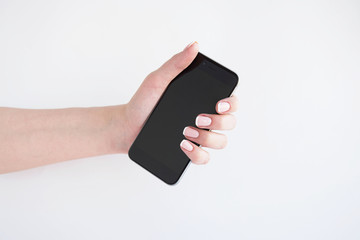 Female hand holding a smartphone, isolated on white background.