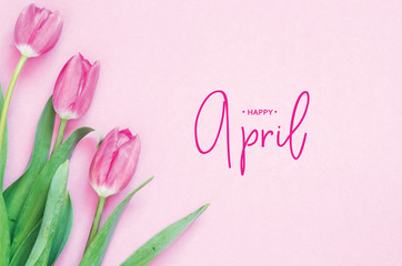 .Inscription Happy April. Tulip flower. Spring background.