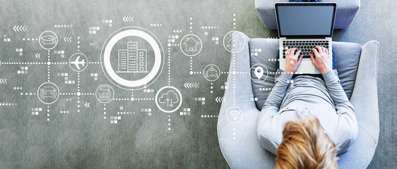 Smart city concept with man using a laptop in a modern gray chair