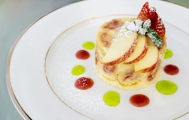 Beautiful strawberry yoghurt desset decorated with apple, berries, mint, sugar powder and colorfel jam dots. Text space