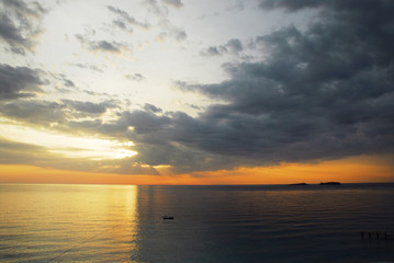 Fototapeta premium Sunset on the sea, half bright, half dark