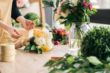 Partial view of florist making bouquet in flower shop