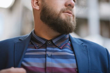 A man with a beard in a warm winter jacket poses for advertising men's clothing in the winter. Advertising of men's clothing