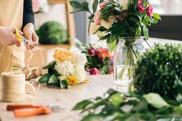 Partial view of florist making bouquet in flower shop