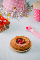 Birthday party items with raspberry pie on table