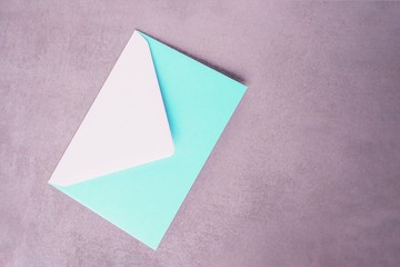 Mint aquamarine envelope on a gray concrete background. Minimal concept, copy space.