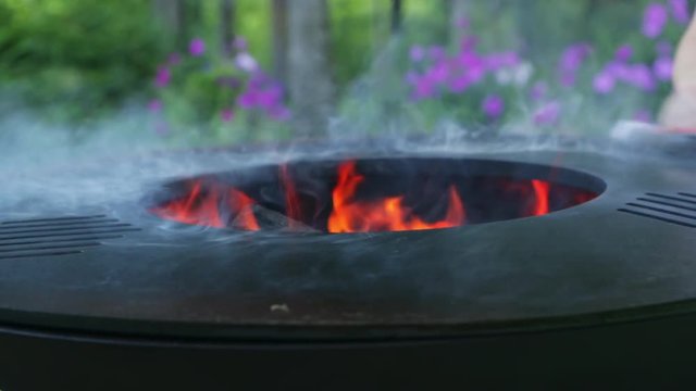 Preparing a new grill for use. Linseed oil on a white cloth. Use of oil for the first calcination of the frying surface. Female hand with a manicure. Happy people having camping and bbq party outdoor.