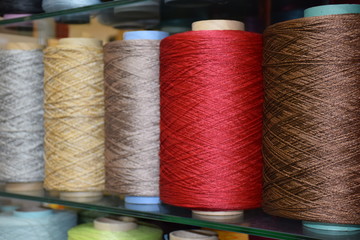 Row of large bobbins of polyethylene thread. Coils of warm tones with a closeup, selective focus.