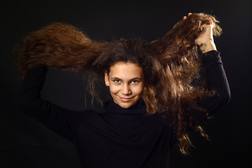 Emotional portrait of a girl with long curly hair on background