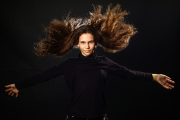 Emotional portrait of a girl with long curly hair on background