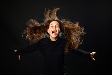 Emotional portrait of a girl with long curly hair on background