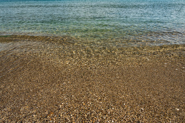 The seabed is pebbly with crystal clear water.