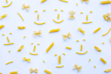 Different types of dry pasta on white.
