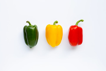 Green, yellow and red fresh bell pepper on white.