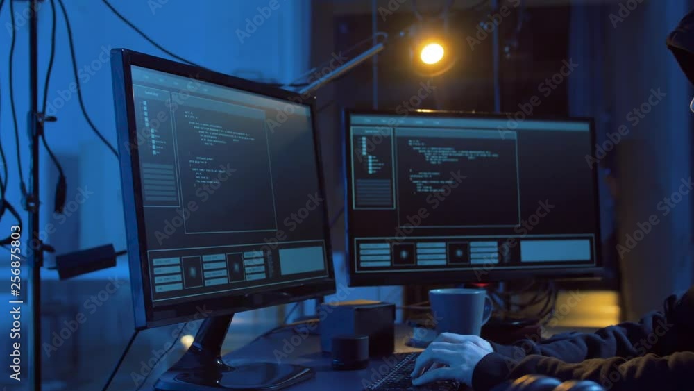 Poster cybercrime, hacking and technology concept - male hacker in dark room creating code or using compute