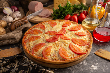 Beautiful pizza with ham and tomatoes
