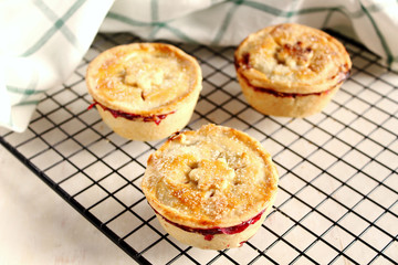 Traditional rustic homemade american  mini cherry pie with golden crust on cooling rack