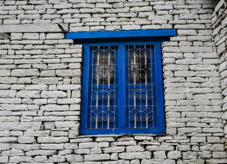 Blue wooden window with brick wall