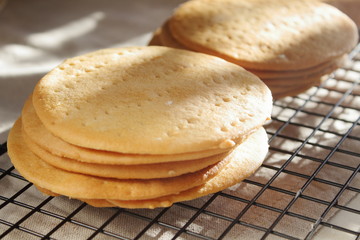 Fototapeta na wymiar A stack of biscuits shortbread cookies pancake cakes for russian layered honey cake on cooling rack