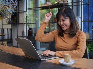 Asian woman using laptop in coffee shop cafe