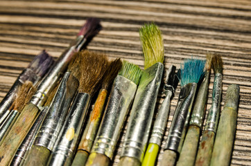 Paint brushes on the wooden background