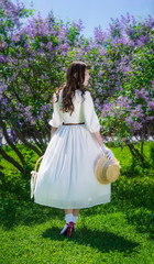 Obraz na płótnie Canvas Woman with a basket in her hands in a walk in garden