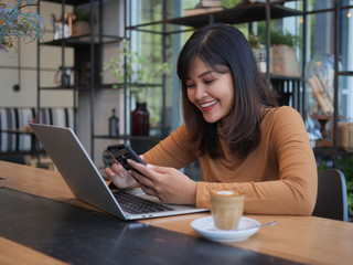 Asian woman using laptop in coffee shop cafe