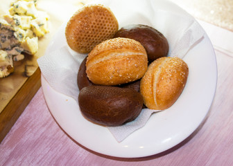 Rolls black and white bread on a white plate